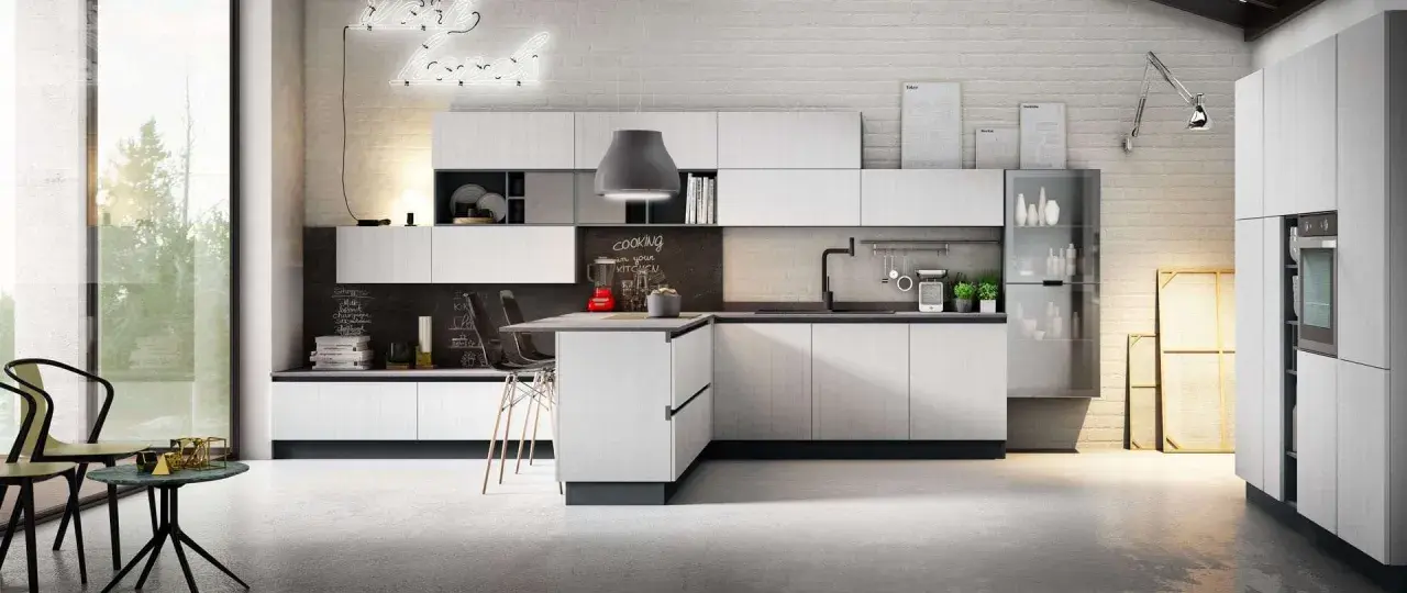 Cucina moderna con isola centrale, pensili bianchi e lavagna con scritta "cooking in your kitchen". Ottima pittura lavabile cucina, opinioni positive per la praticità.