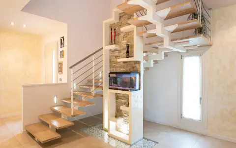 Moderna scala interna in legno e metallo con acquario integrato. Il design innovativo suggerisce un interessante costo scala interna.