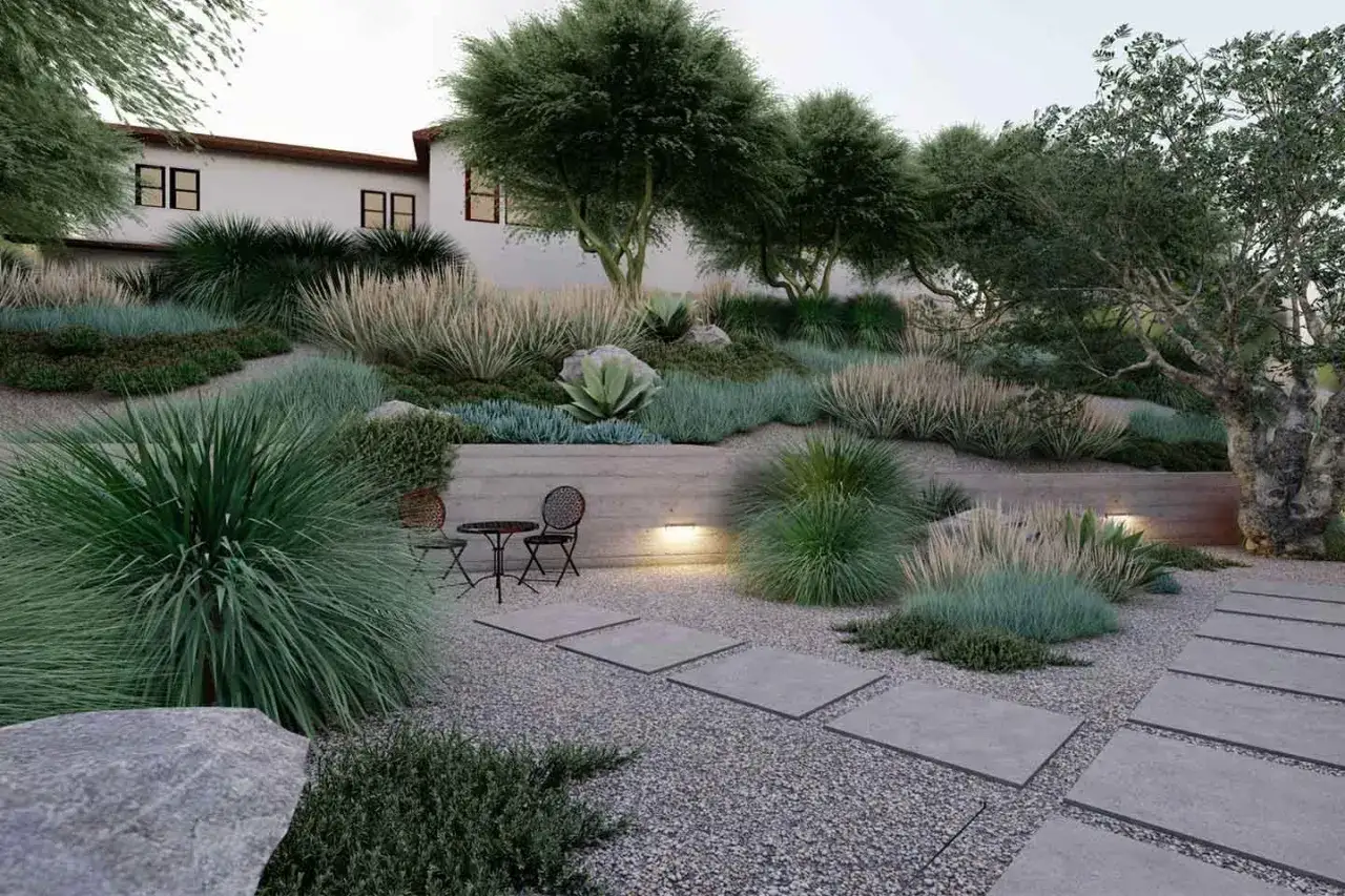 Un moderno camminamento giardino con lastre in cemento e ghiaia, circondato da erbe ornamentali e un ulivo secolare.