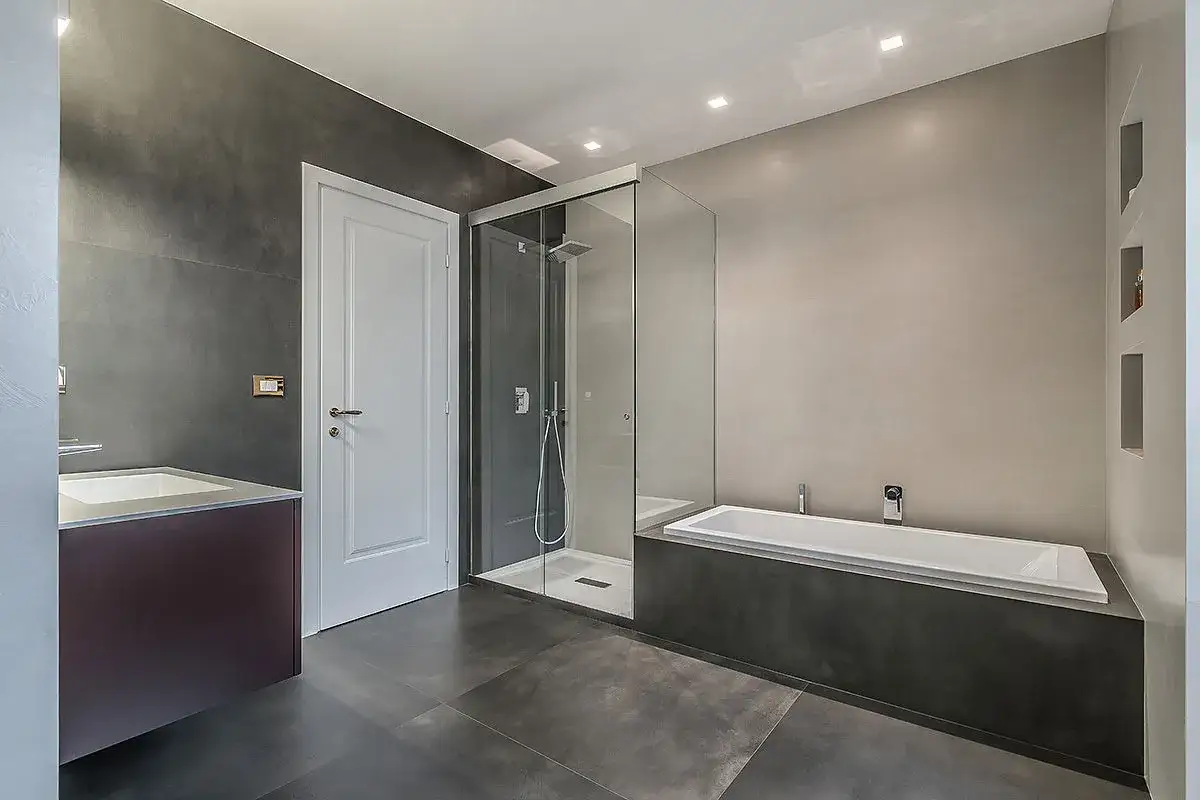 Bagno moderno con doccia a nicchia in vetro, vasca e lavabo. L'altezza della nicchia doccia &egrave; ben integrata nel design.