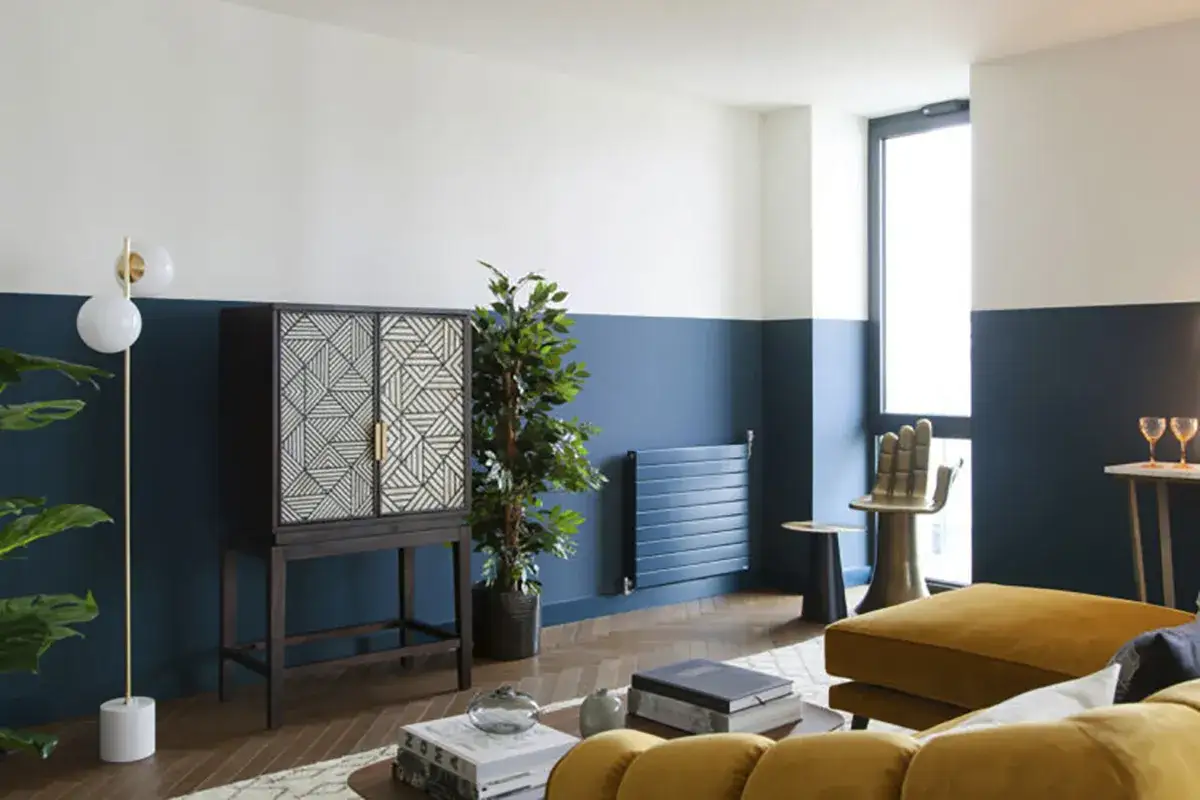 Soggiorno moderno con pareti bicolore, blu e bianco, per ispirarti su come scegliere colore pareti. Arredi di design e piante.